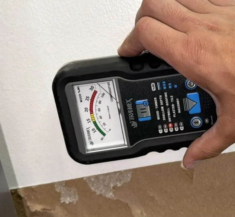 Crestline technician checking wall moisture with a meter