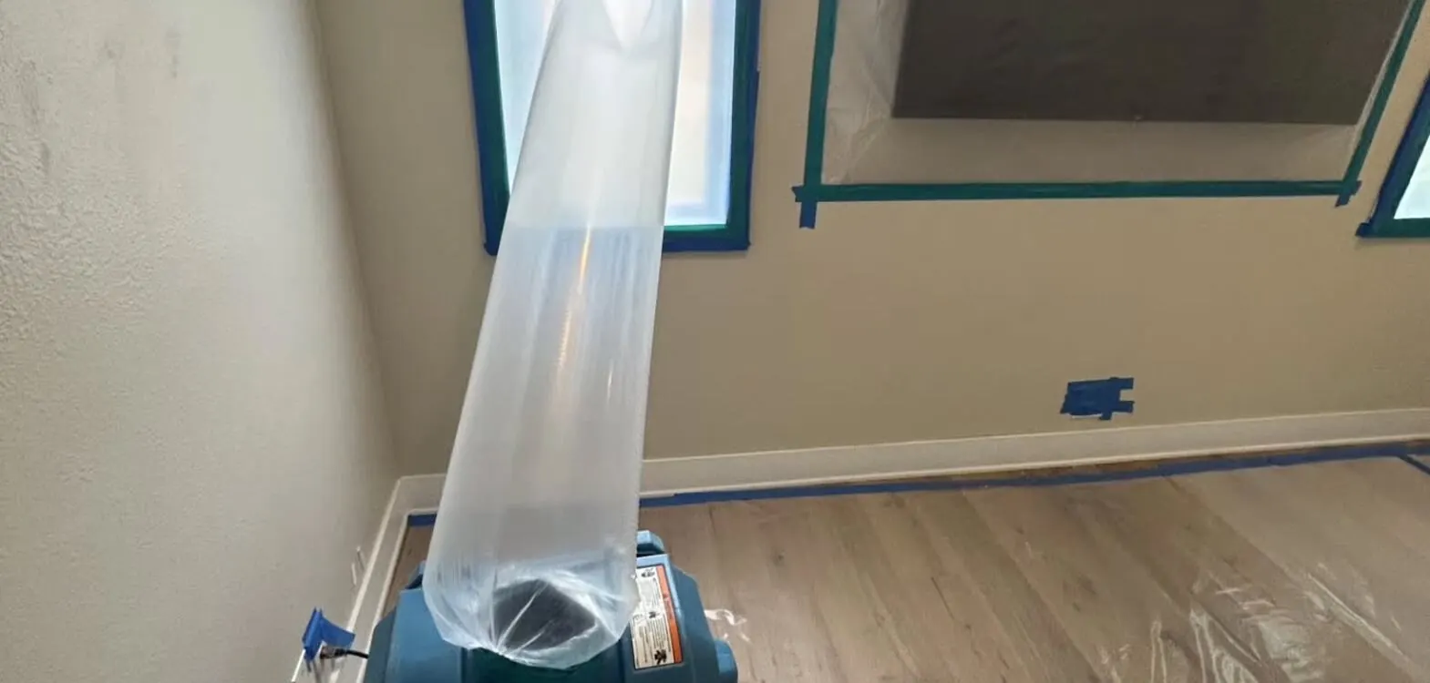 HEPA air scrubber venting through a window during restoration
