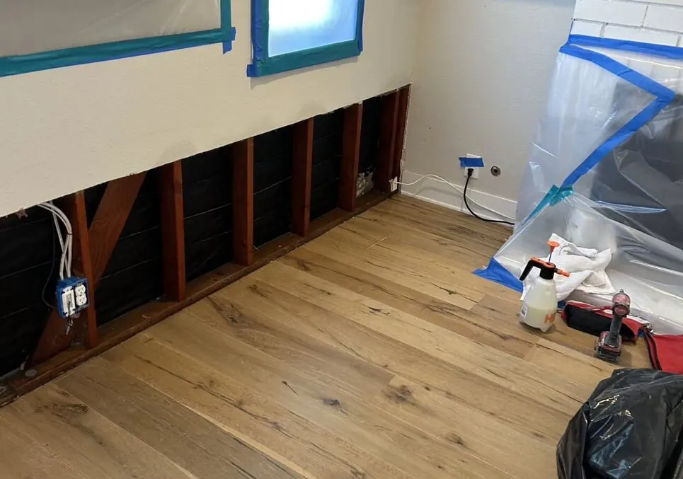 Flood cut and open wall cavities drying above engineered hardwood