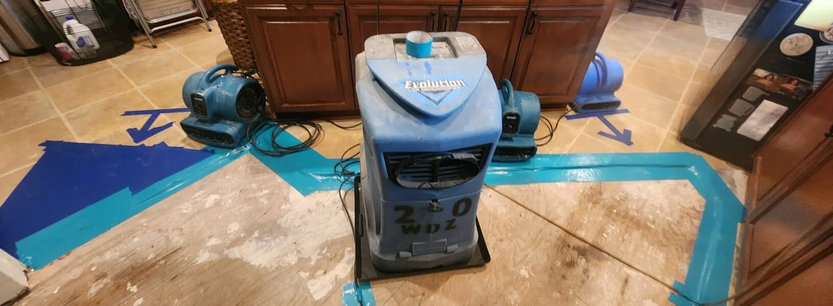 Kitchen subfloor drying with a dehumidifier and air movers after a leak